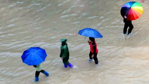 People make their way across a flooded street in Shangsi, China, on November 11. Haiyan moved toward Vietnam and south China after devastating the Philippines.
