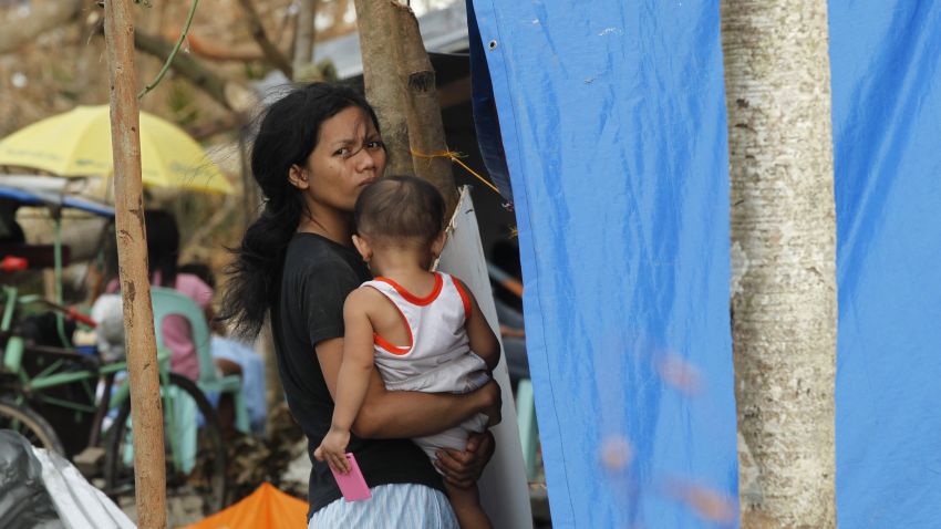 A woman cuddles her child at a makeshift shelter following the massive destruction caused by Typhoon Haiyan in Tacloban, central Philippines, Monday, Nov. 11, 2013. Typhoon Haiyan, one of the strongest storms on record, slammed into six central Philippine islands on Friday leaving a wide swath of destruction and hundreds of people dead. (AP Photo/Wally Santana)