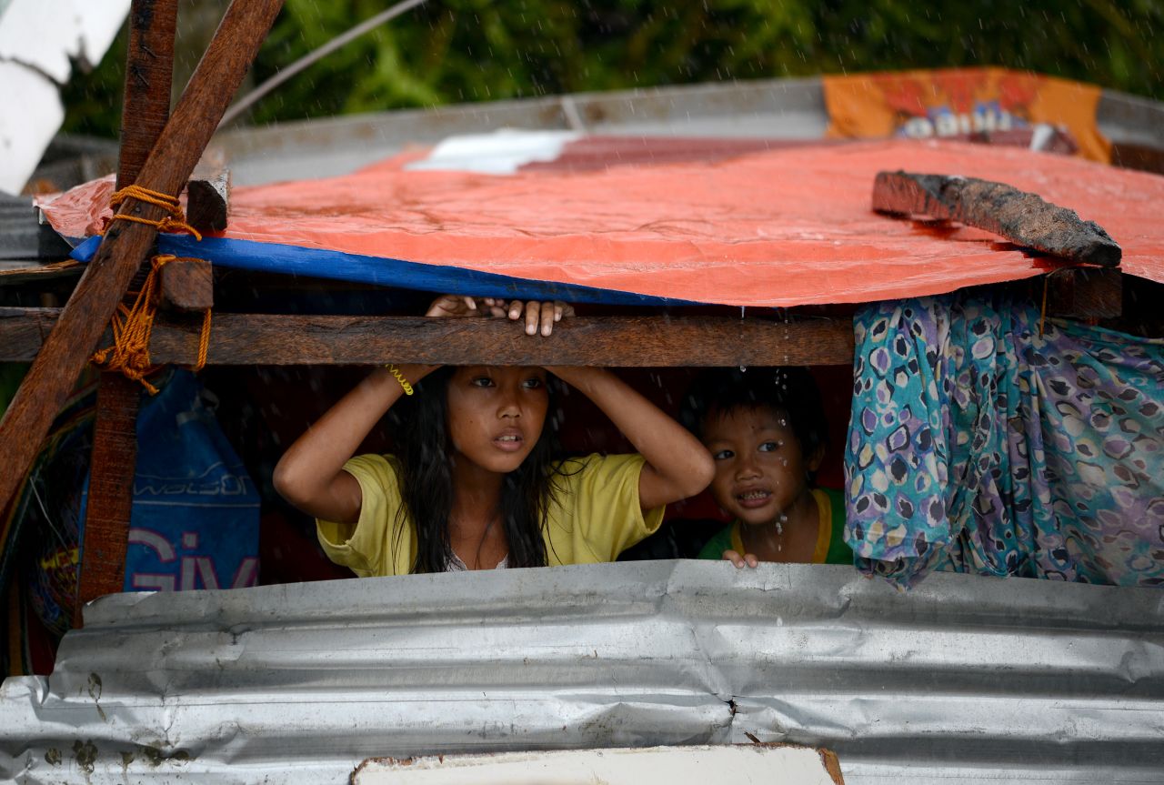 Niños se asoman desde su refugio improvisado en Tacloban, el domingo 10 de noviembre.