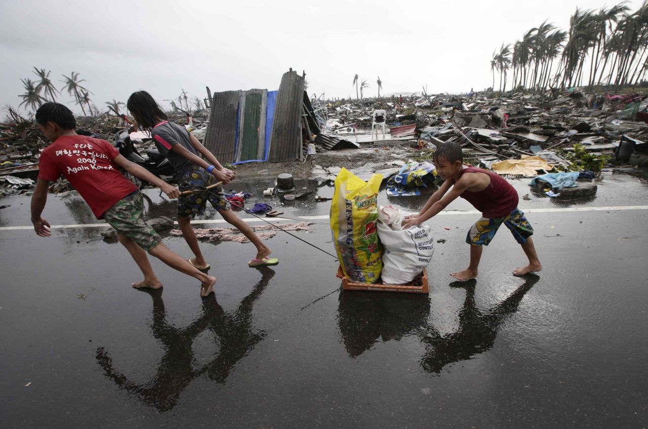 Niños arrastran ayuda en medio del panorama devastador en Tacloban, el 10 de noviembre.