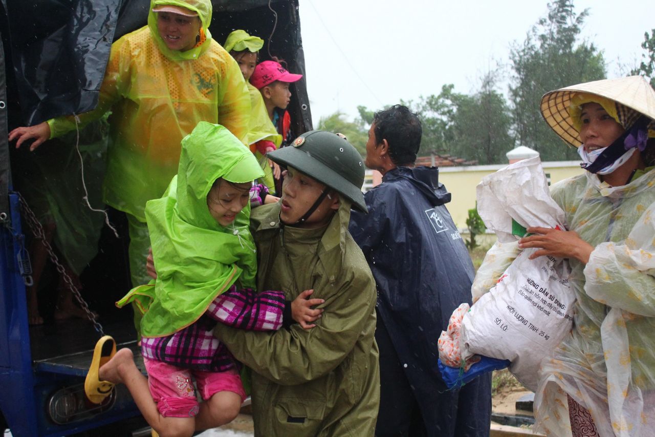 Un soldado vietnamita ayuda a una niña el sábado 9 de noviembre.