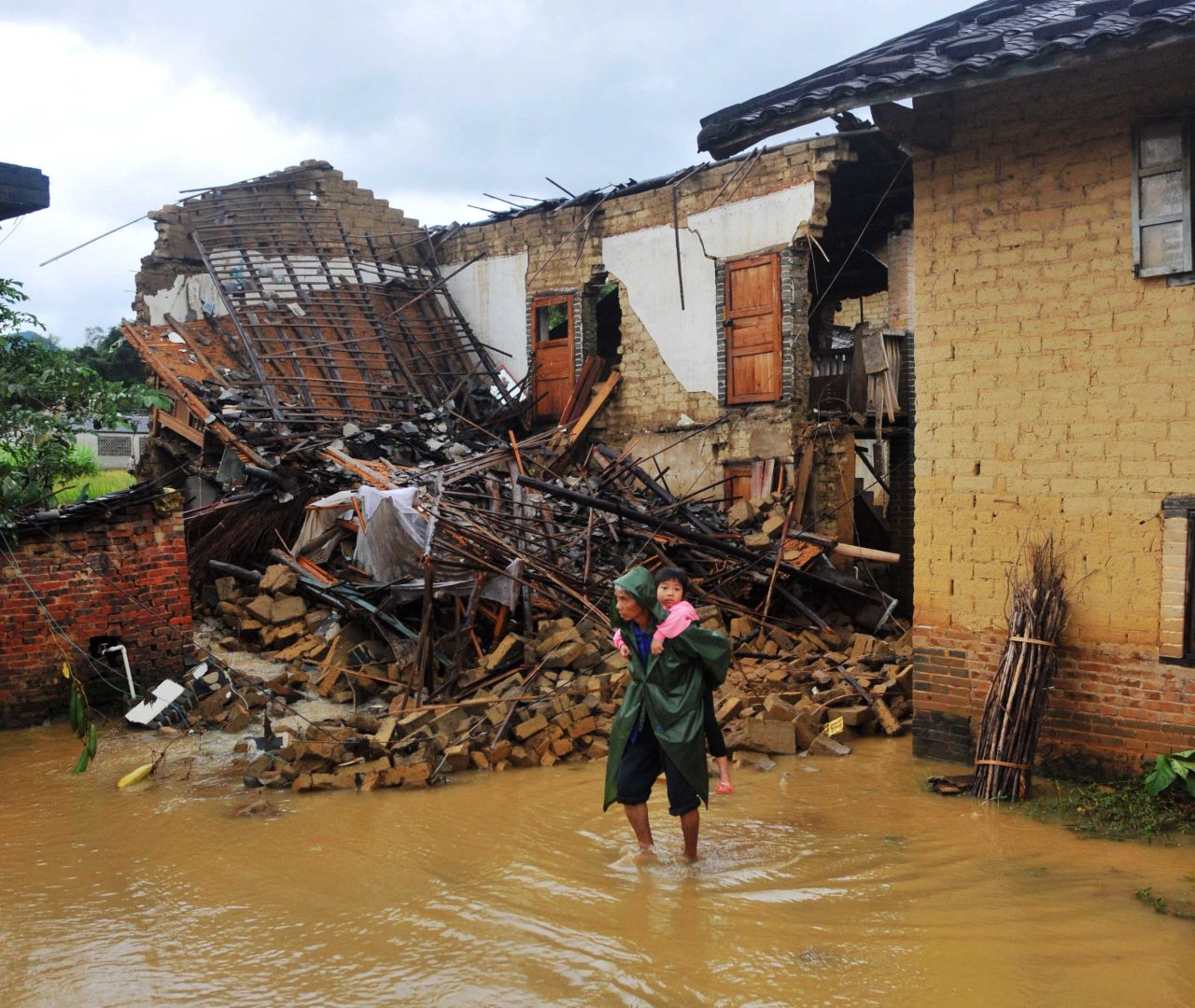 Una mujer lleva a un niño a través de una calle inundada en Yong'an, China, el 11 de noviembre. China y Vietnam también fueron duramente golpeados por la tormenta.