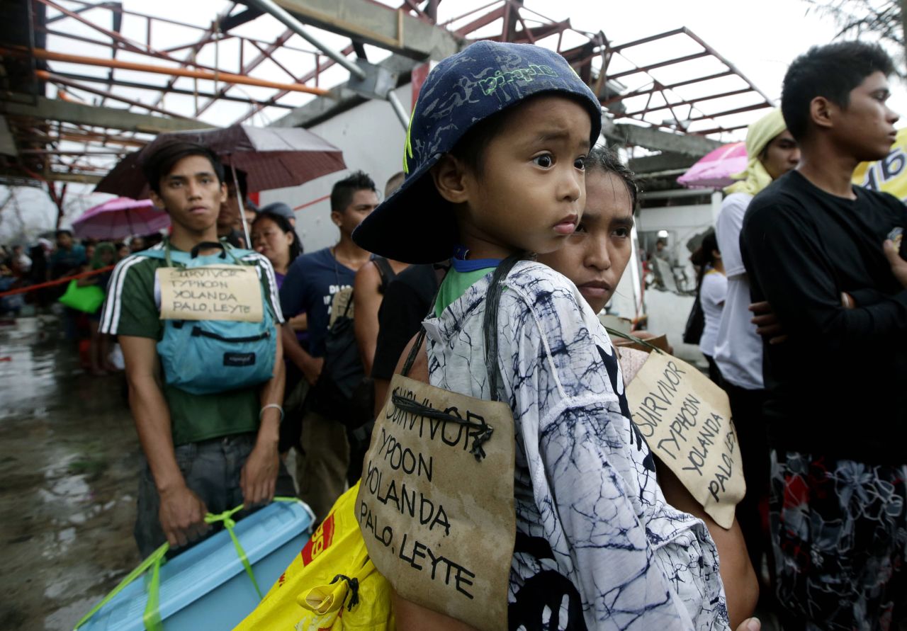 Sobrevivientes del tifón hacen fila el 12 de noviembre con la esperanza de embarcar en un avión de transporte militar de Tacloban.
