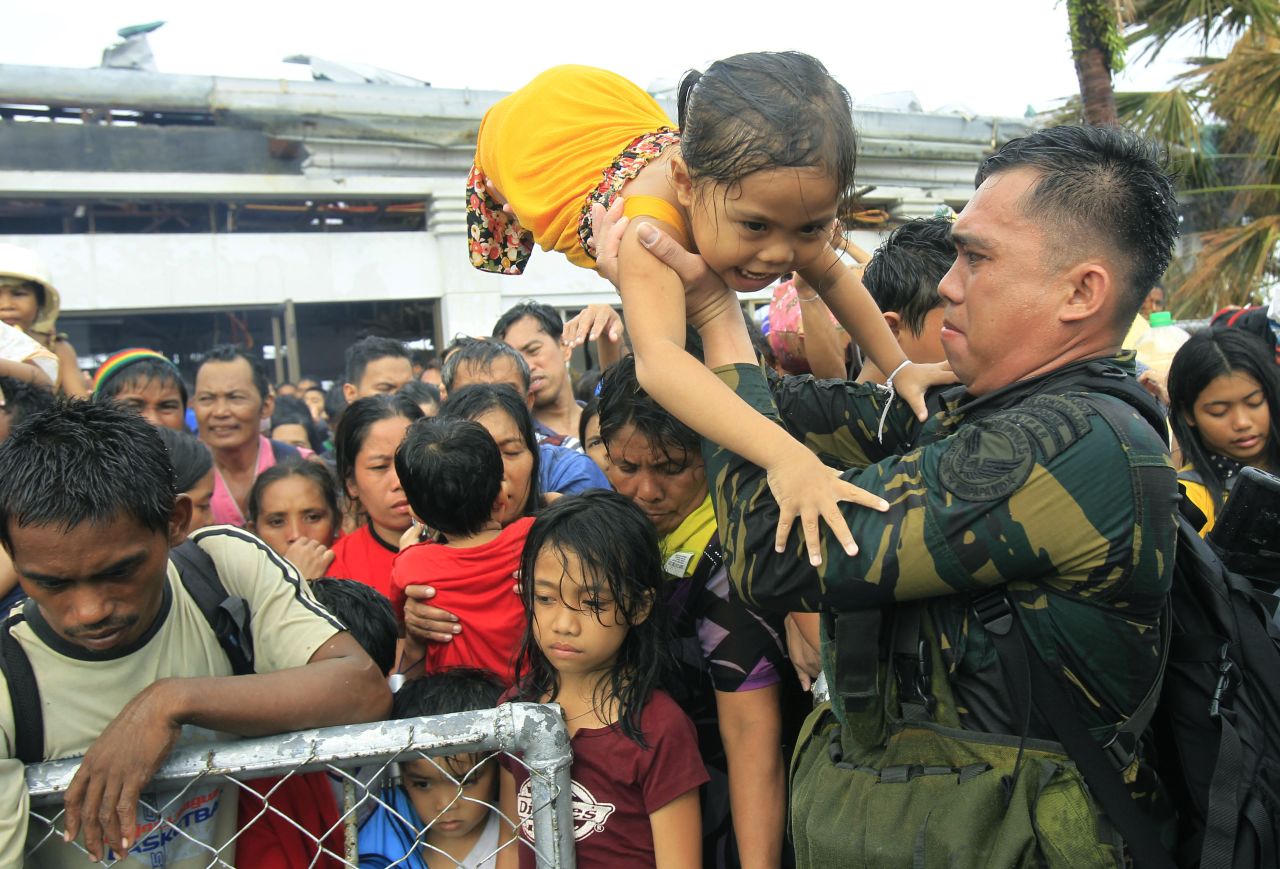 Personal militar de Filipinas trata de dar prioridad a los niños y las mujeres en los vuelos de evacuación, el 12 de noviembre en Tacloban.