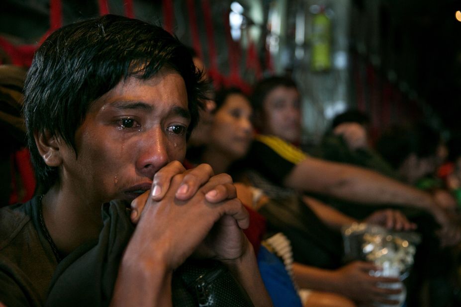 A man sits crying on a packed aircraft in Tacloban on November 12.