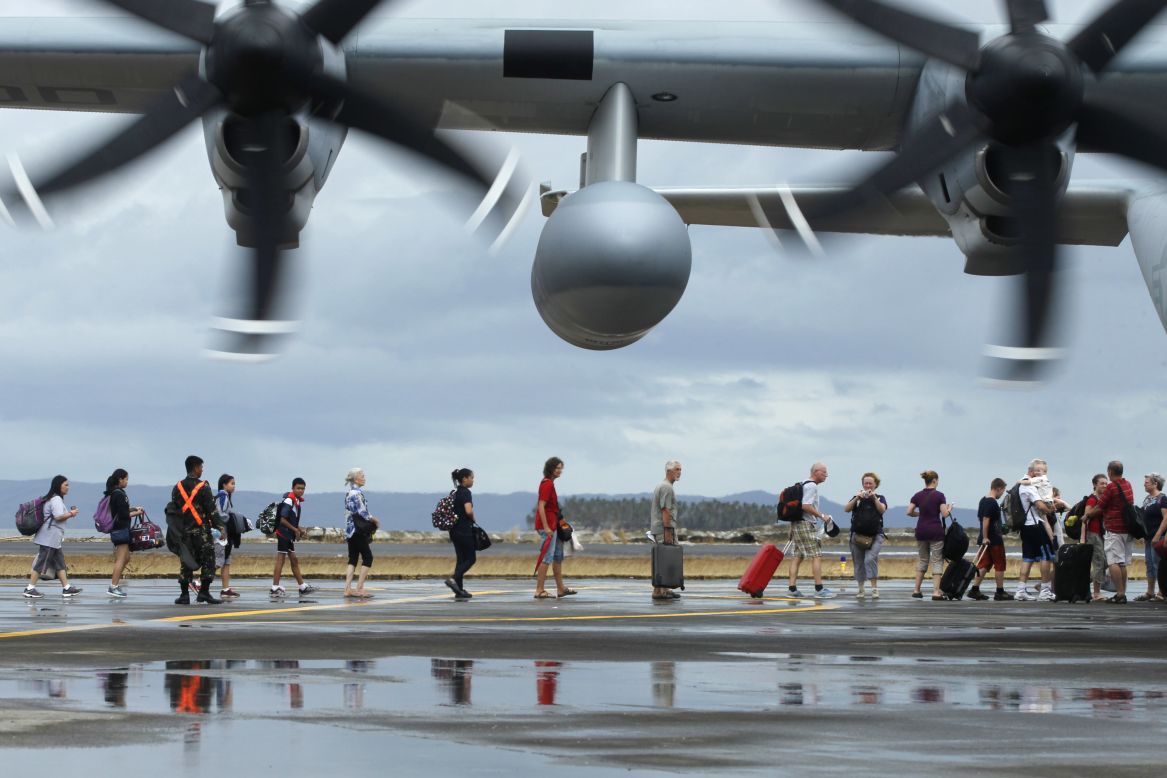 People board a U.S. military plane to evacuate Tacloban on November 12.