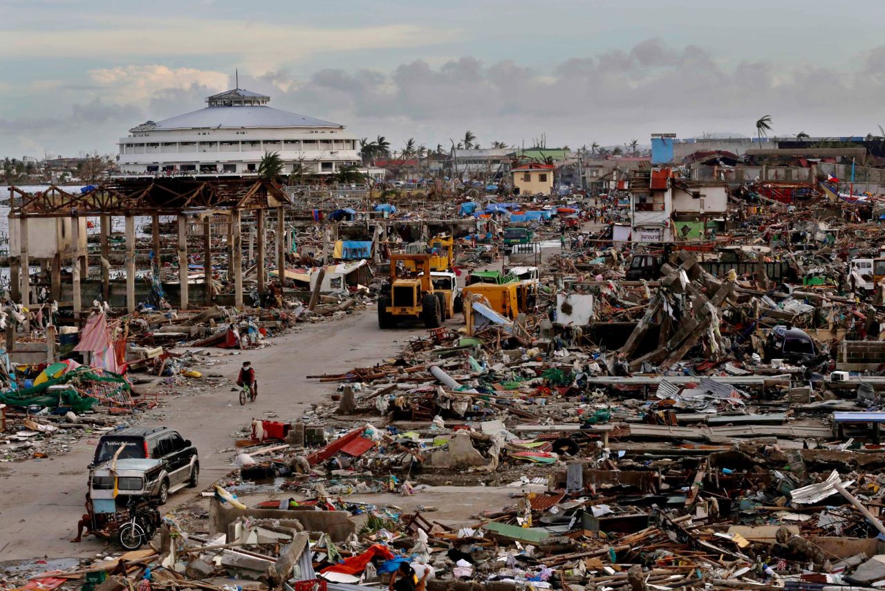Residents make their way through a destroyed neighborhood in Tacloban on November 13.
