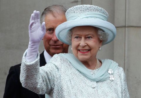 The Queen waves from the balcony of Buckingham Palace as Charles, stands behind her, during the finale of the Queen's Diamond Jubilee celebrations on June 5, 2012, in London. 