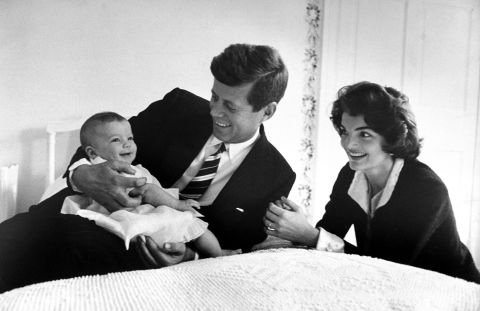 The Kennedy's cuddle daughter Caroline while relaxing on a bed at home on March 25, 1958.