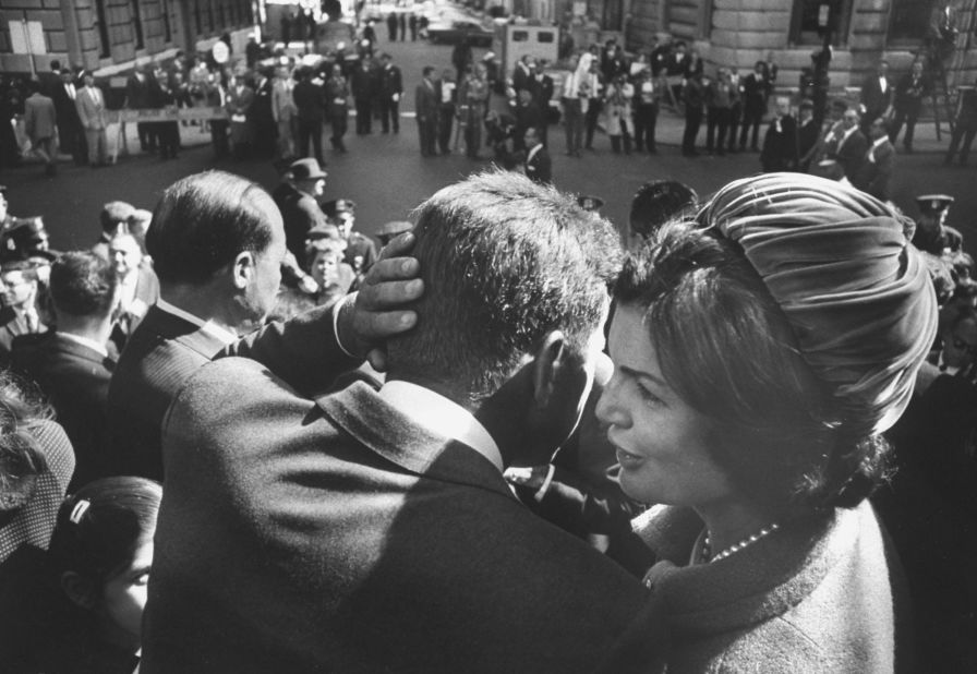 Kennedy, campaigning for president, listens to the whispers of his wife in 1960. 