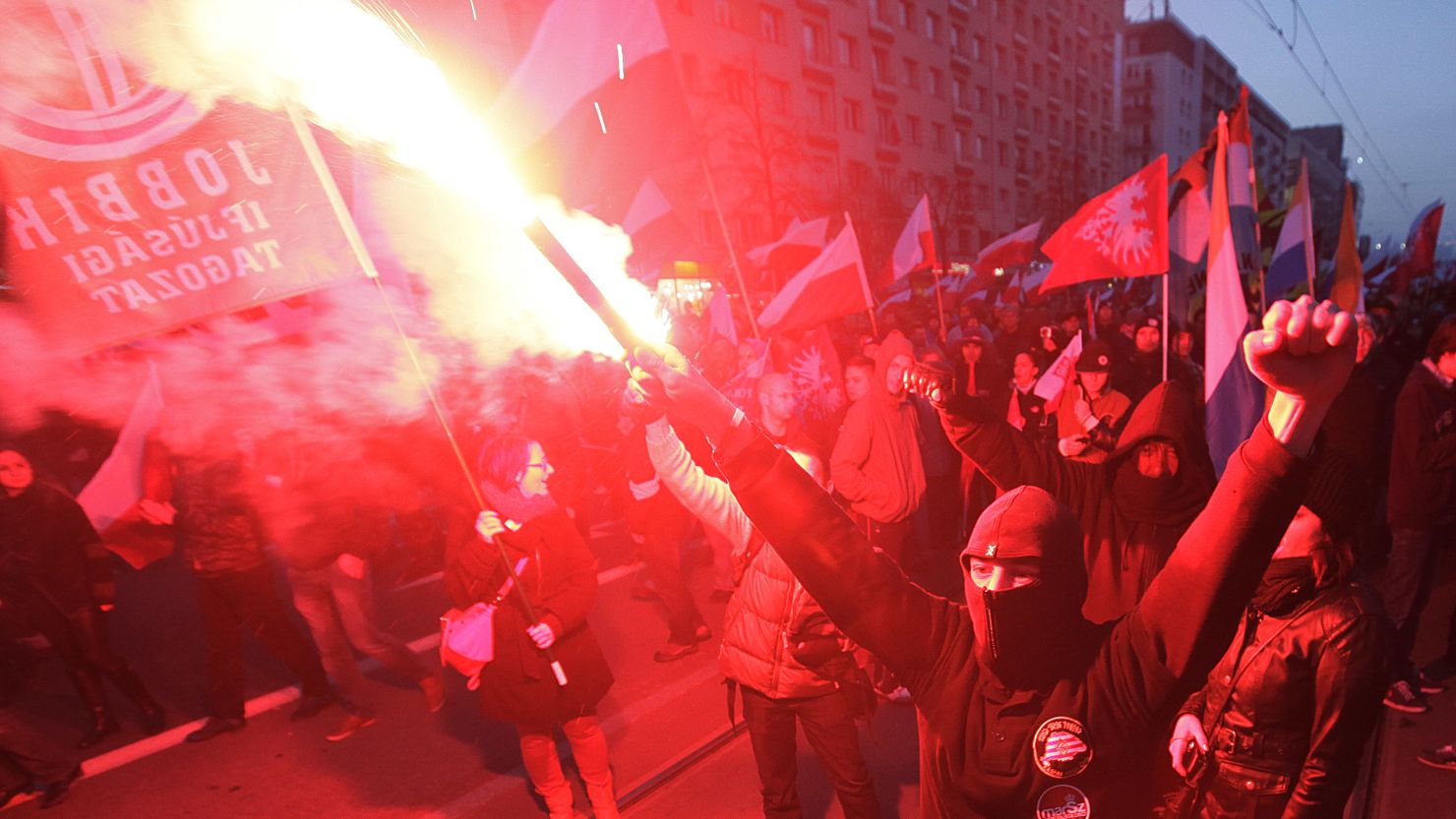 People hold burning flares as they march through the the centre of Warsaw, Poland on Monday,  November 11.