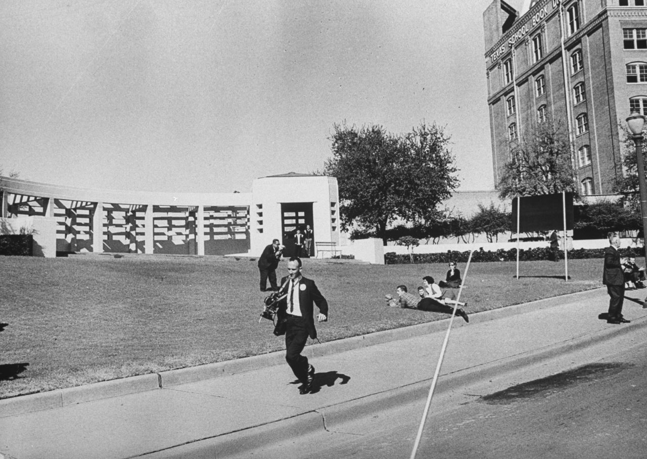 Photographers are seen running shortly after the shooting.