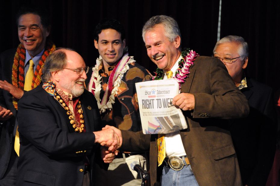 On November 13, 2013, Hawaii Gov. Neil Abercrombie, left, and former state Sen. Avery Chumbley celebrate with a copy of the Honolulu Star-Advertiser after Abercrombie signed a bill legalizing same-sex marriage in the state.