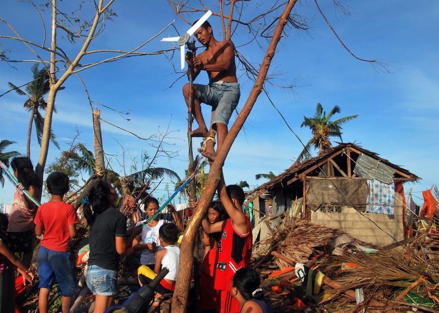 A family, desperate to charge their mobile phones to search for family and friends, tries to use a ceiling fan to generate electricity November 13 in the Philippine province of Cebu.