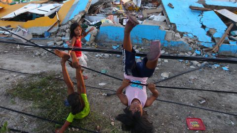 Children play with fallen power lines near a damaged school in Guiuan on November 14.