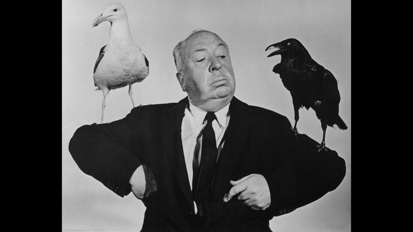 British film director Alfred Hitchcock poses with a seagull and a raven in a promotional still for his film "The Birds." The film was released on March 28, 1963.