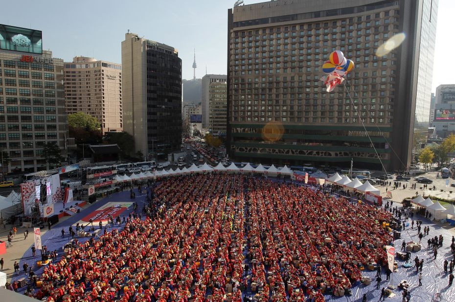 Travelers staying at The Plaza hotel (top right) were treated to an unusual sight: Seoul housewives filled the 13,207-square-meter Seoul City Plaza for the largest kimchi-making event to date. 