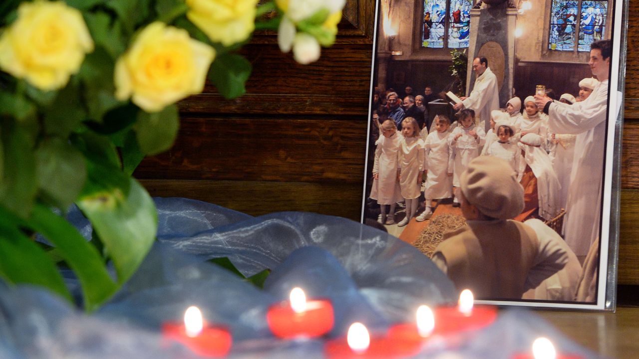 Candles and flowers sit next to a photo of kidnapped priest Georges Vandenbeusch during a Thursday vigil south of Paris. 