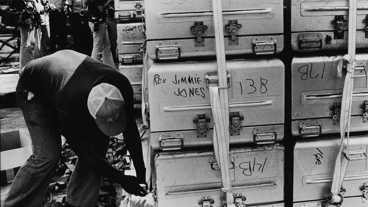 An unidentified man straps a stack of aluminum coffins for shipment to the United States. 