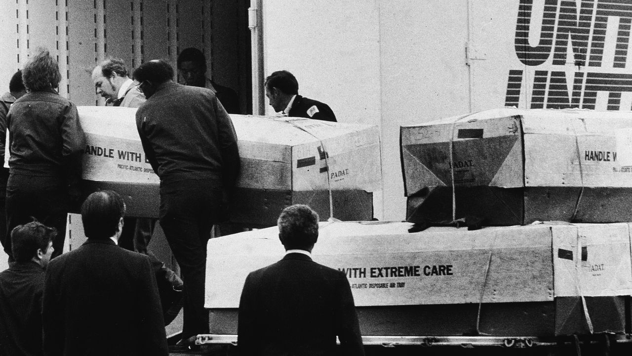 Men load coffins from Jonestown, into a transport truck in Dover, Delaware, on April 26, 1979.
