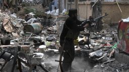 A rebel fighter fires his weapon as he stands amidst rubble and debris during clashes with Syrian government forces in Deir Ezzor, Syria on November 11.