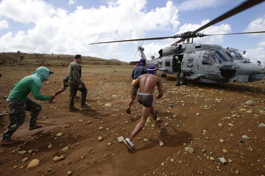 Trapped residents prepare to unload relief supplies from a U.S. Navy helicopter November 16.