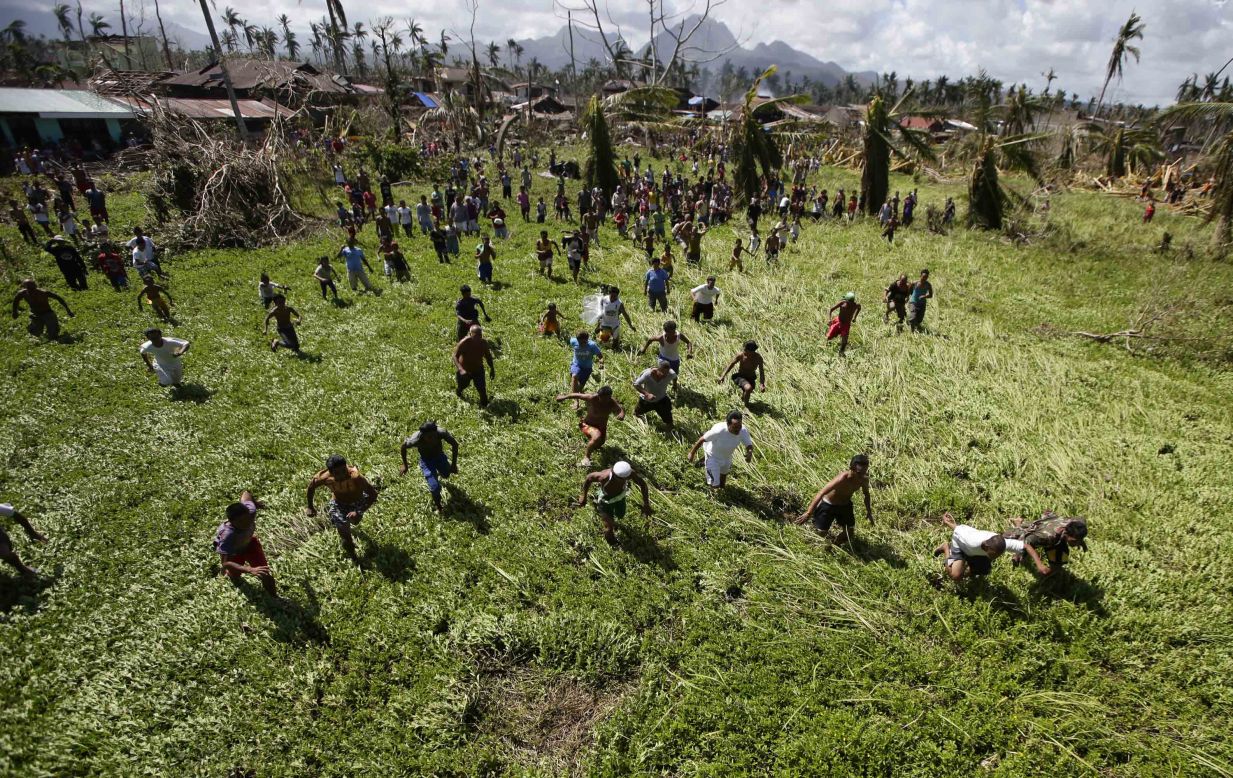 Villagers isolated by the typhoon scramble for relief goods being dropped by the Philippine Air Force on Friday, November 15, in La Paz.