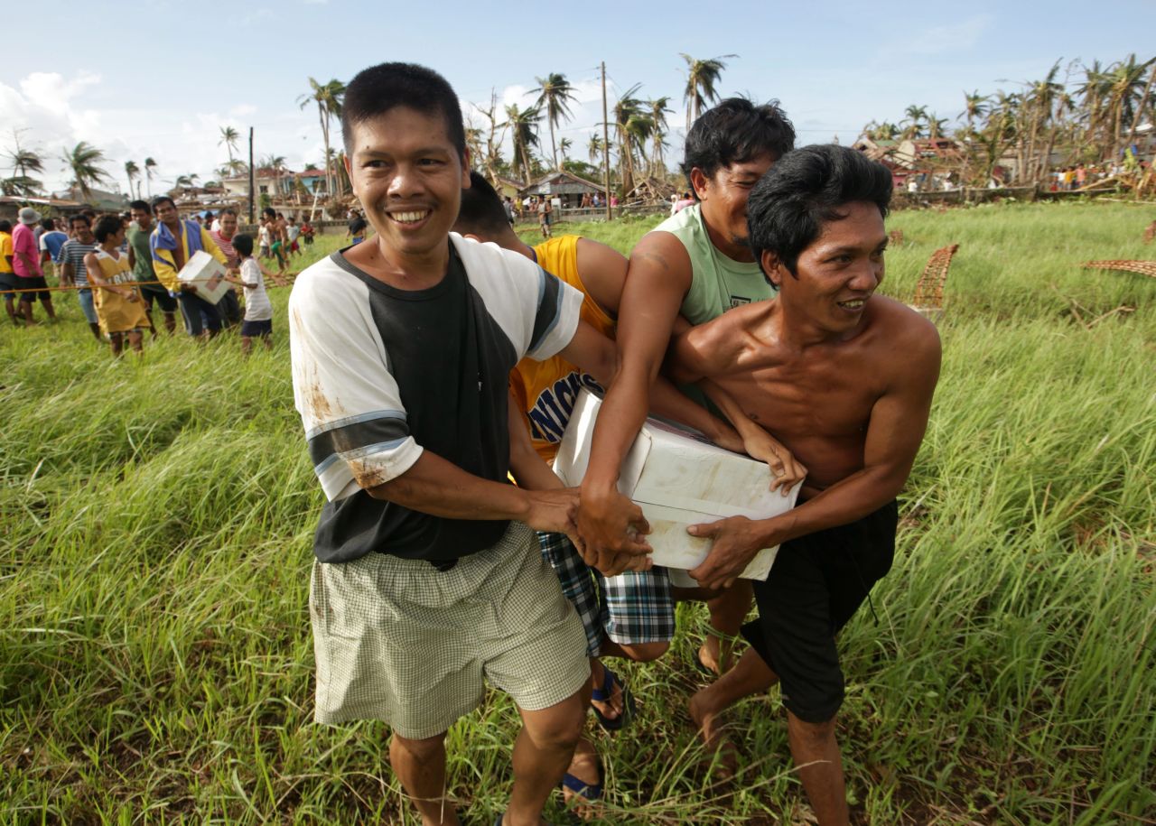 Typhoon victims in Salcedo, Philippines, hold onto a box of relief goods received November 16 from a U.S. Navy helicopter.