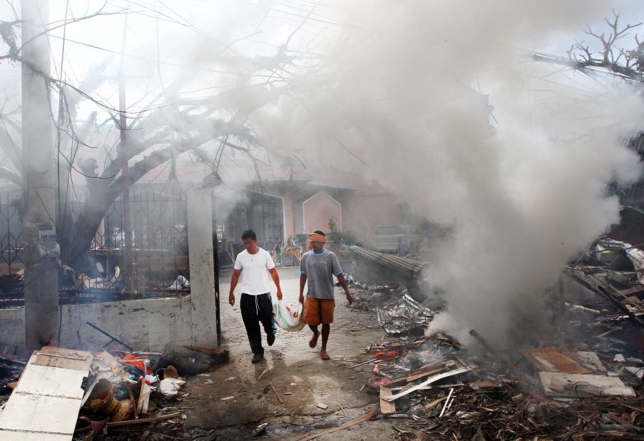 Men walk through smoke as they burn debris from a Tacloban church on November 16.