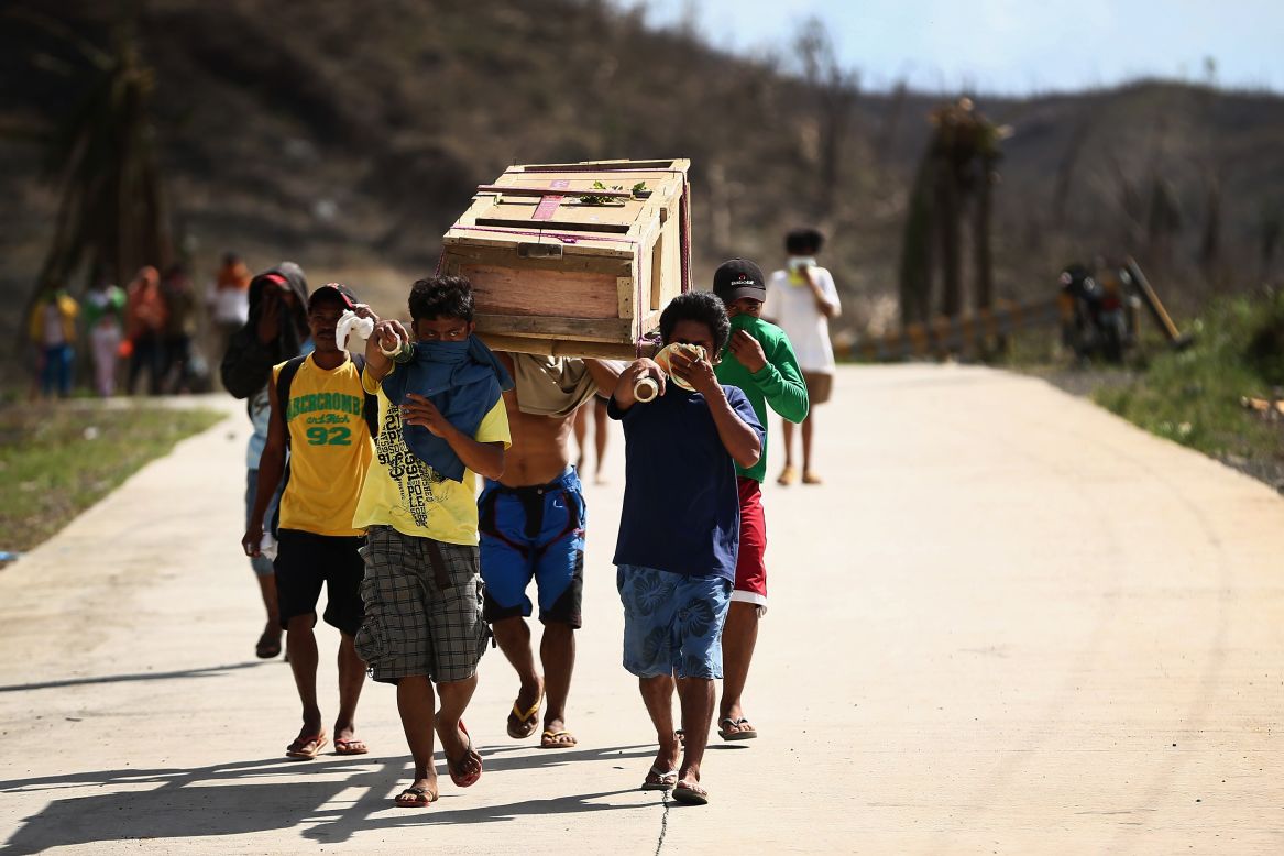 Hombres cargan un ataúd hacia el cementerio local el 16 de noviembre en Leyte, Filipinas. Todavía se recogen cuerpos de las calles.<br />