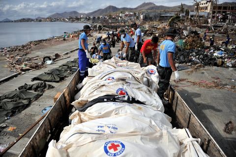 Corpses are collected and loaded on trucks to be taken to mass graves in Tacloban on November 16.