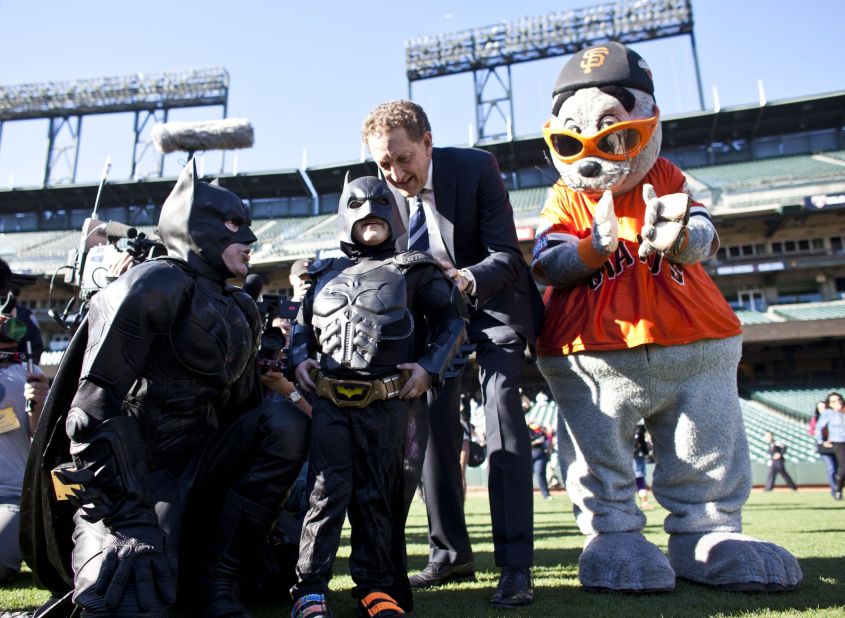 Larry Baer, CEO of the San Francisco Giants, and the team's mascot Lou Seal escort Miles and Batman at AT&T Park.