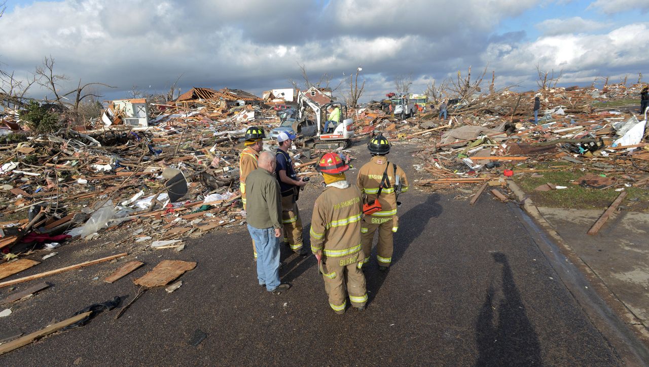 Firefighters stand in the middle of the street after a tornado leveled at homes in Washington, Illinois, on November 17.