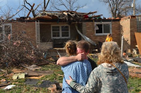Ray Baughman embraces family shortly after his home was destroyed by a tornado south of Peoria in Pekin, Illinois, on November 17. 