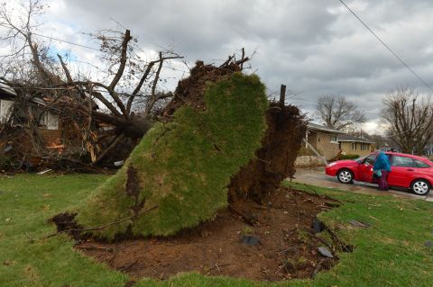A home is damaged by a tree that was uprooted during the storm in Pekin on November 17. Pekin is part of the cluster of towns in central Illinois hit hard by the severe weather.