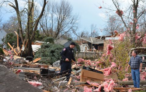 A police officer talks with a resident in Pekin after a tornado touched down in the area on November 17.