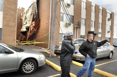 An apartment manager warns Illinois State University students to stay back from a roof that blew off "The U" student apartments in Normal, Illinois, on November 17.