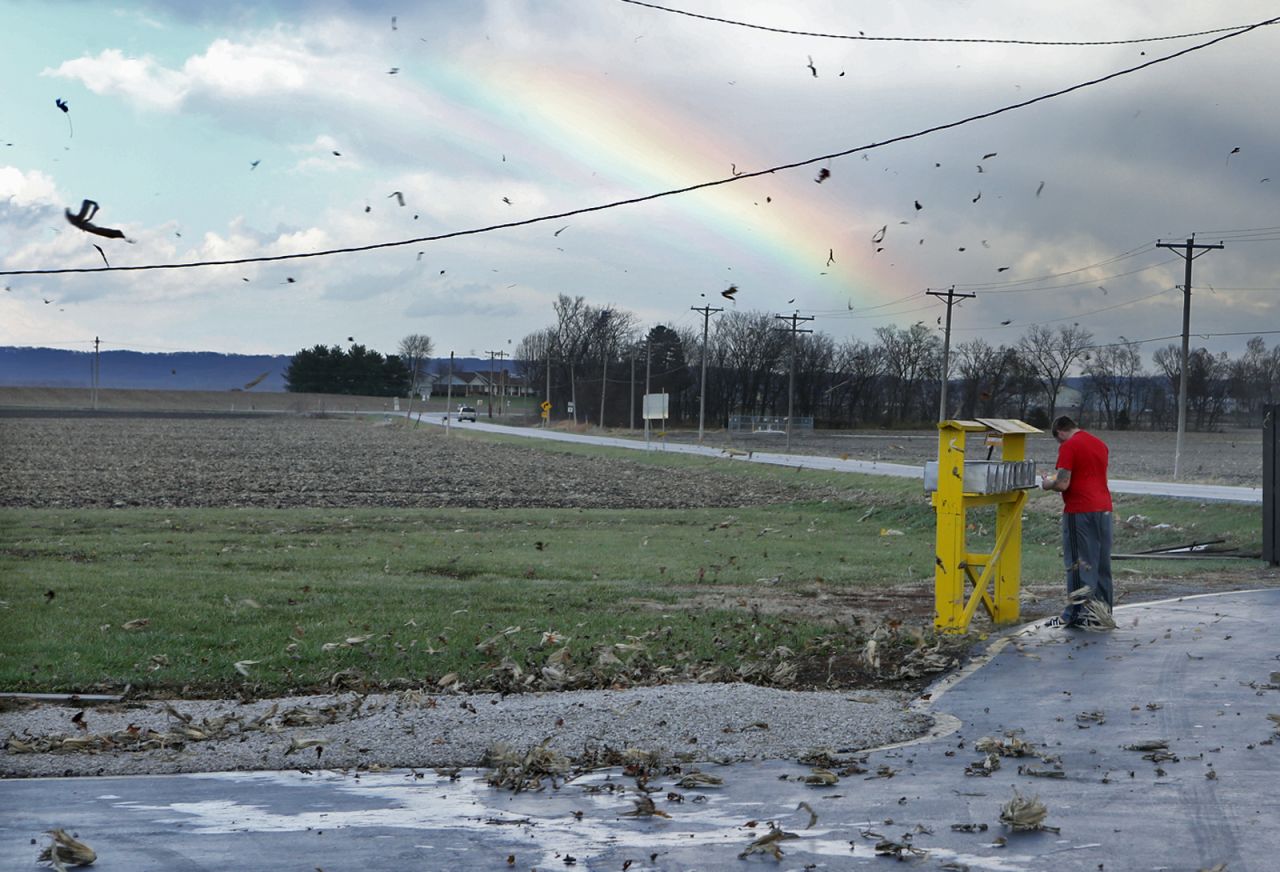 Corn husks fly through the air as Eric Crawford checks his mail after the storm passed in rural Orchard Farm, Missouri, on November 17.