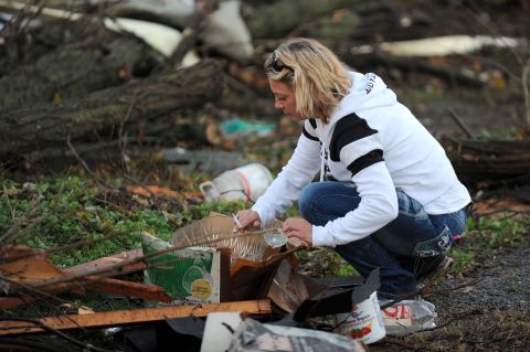 Maranda Souders picks up a crystal bowl and cup while searching through debris from her grandmother's home in Brookport, Illinois, after a tornado hit the small town in far southern part of the state on November 17.