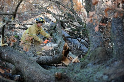 A firefighter works to clear a tree from a street in Brookport, Illinois, on November 17.