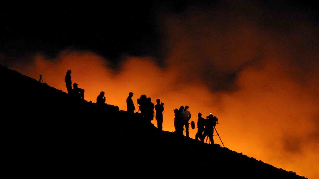 Reporters watch lava flow down Etna in 2001.