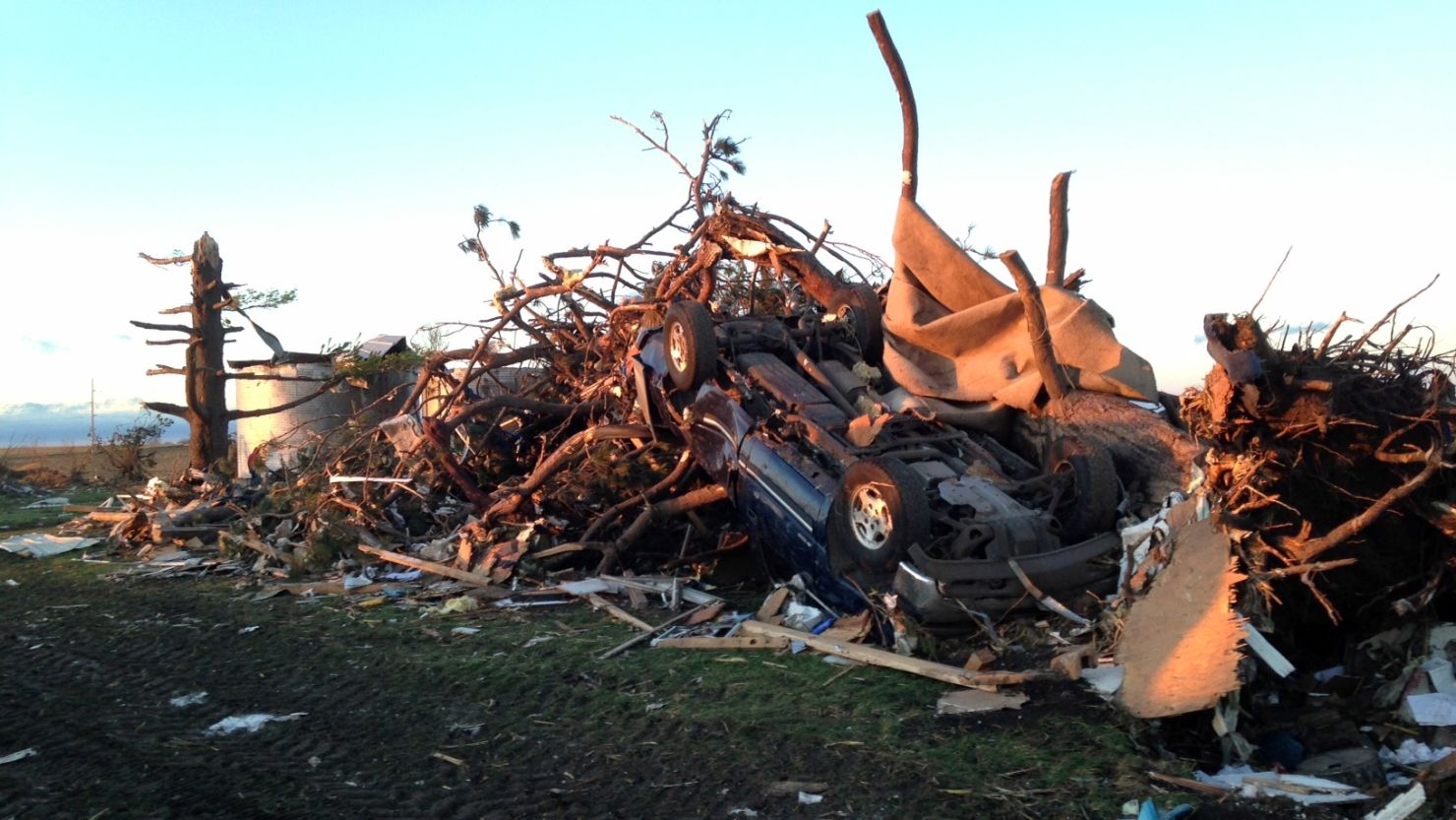 An overturned car rests atop tree branches and other rubble near Washington, Illinois, on Sunday.