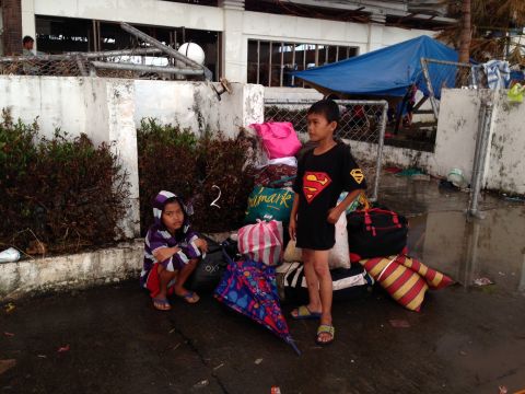 These two young boys wait patiently to get on a plane out of storm-ravaged Tacloban on November 13.