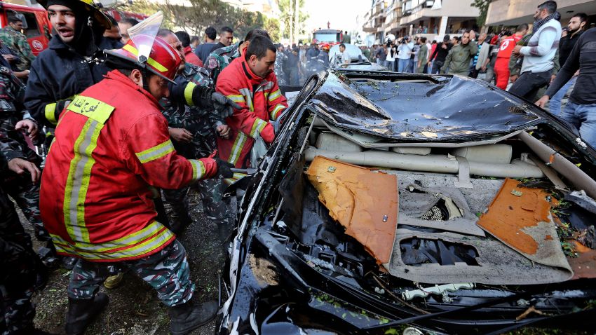Lebanese Red Cross workers pull a body from a car.