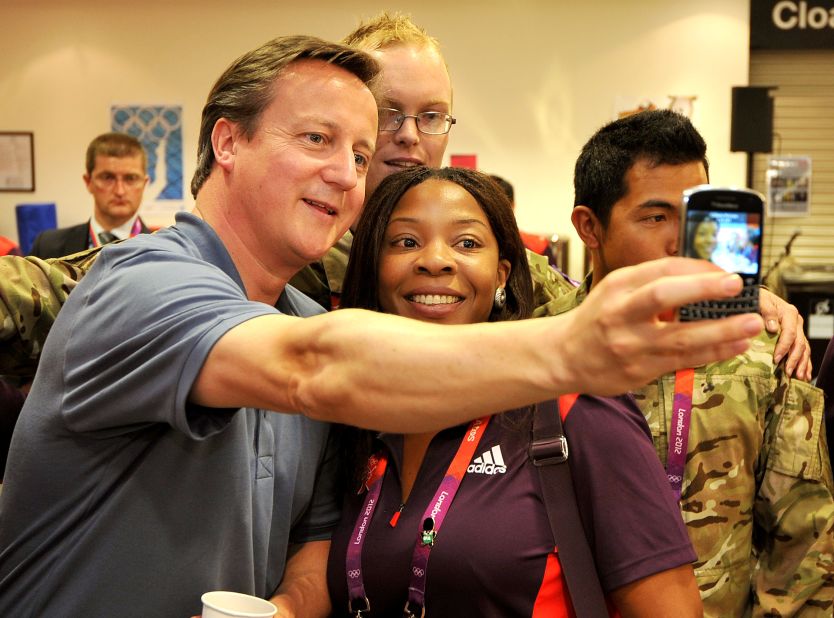 Even political figures are getting in on the trend. Here, British Prime Minister David Cameron takes a photograph with Olympic volunteer Anita Akuwudike in London.