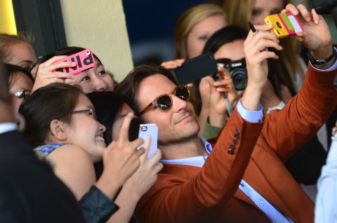Actor Bradley Cooper poses for selfies with eager fans at the Los Angeles premiere of "The Hangover Part III."