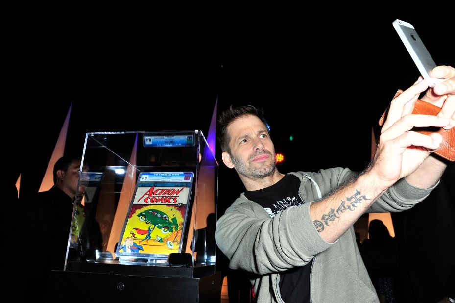 Selfies don't always have to be with other people. Director Zack Snyder takes a photo of himself in front of Action Comics No. 1 at the Superman 75 party in San Diego.
