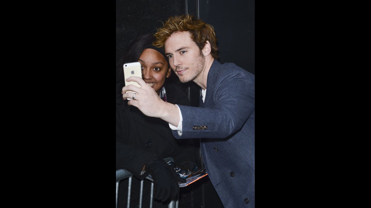 Actor Sam Claflin poses for photos with fans in New York City. 