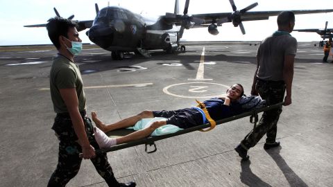 Philippine military personnel carry an injured survivor to an evacuation flight at the Tacloban airport November 19.