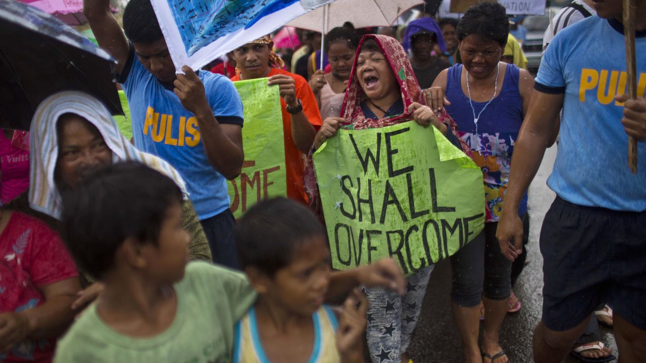 People in Tacloban march in the rain November 19 during a procession calling for courage and resilience among survivors.